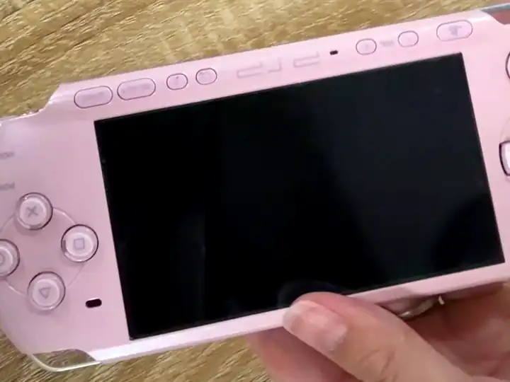 中古ゲーム機を手に取って状態を確認する