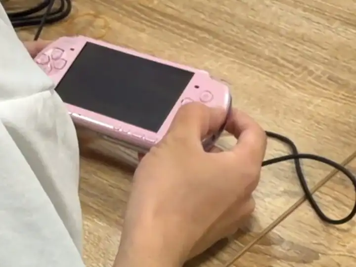 作業机でゲーム機を操作する手元